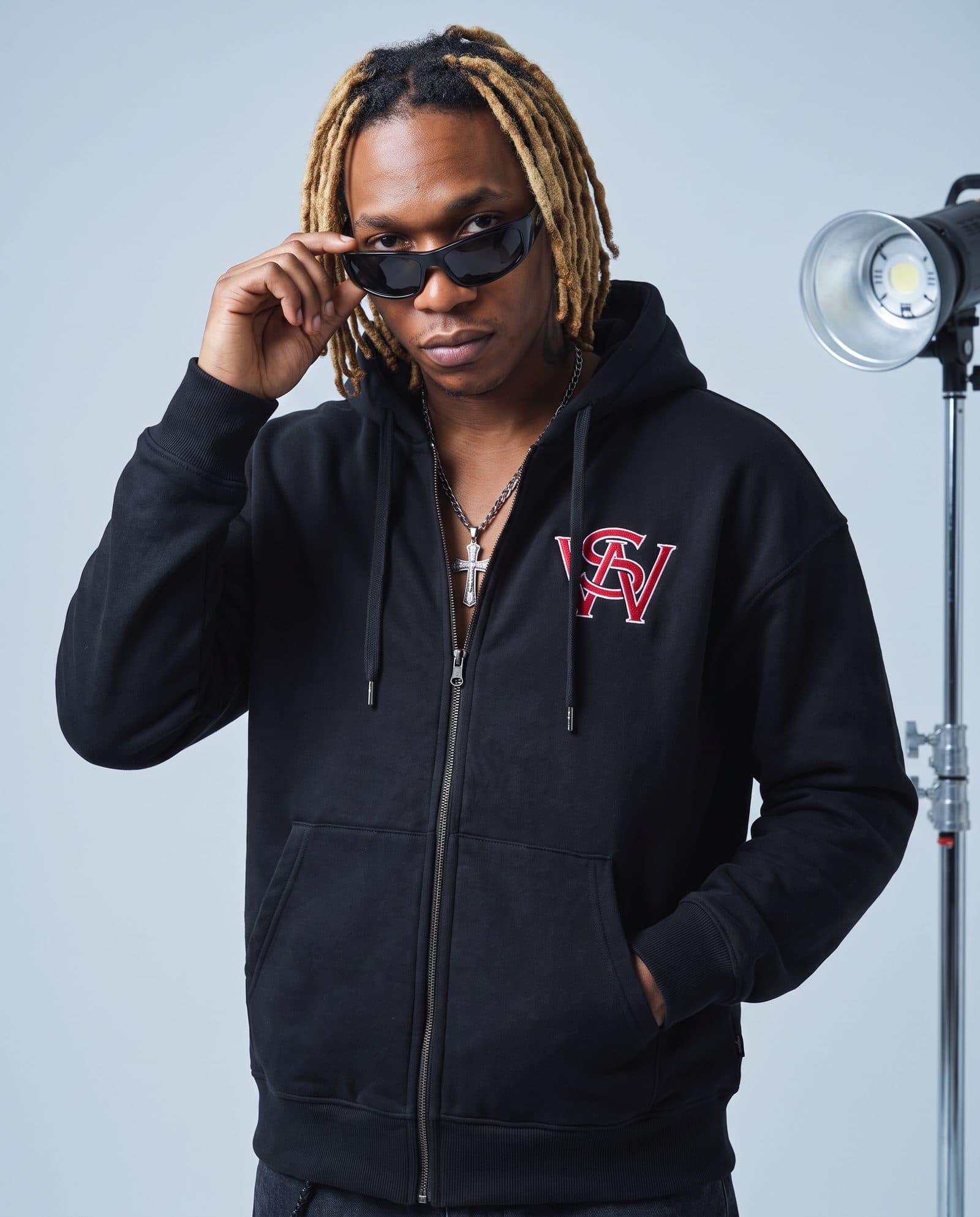 Model in the black Slapwoods zip hoodie, lowering his sunglasses